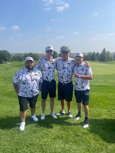 Team golf outing — associates in matching shirts on the course, casual and fun