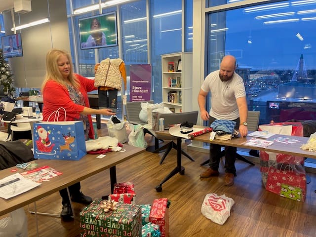 Associates wrapping holiday gifts together in the office — giving back and celebrating the season